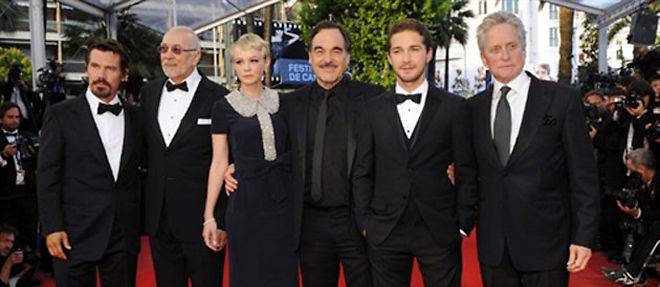 Le realisateur americain Oliver Stone entoure de l'equipe de son film "Wall Street", vendredi, a Cannes (C) AFP PHOTO / ANNE-CHRISTINE POUJOULAT