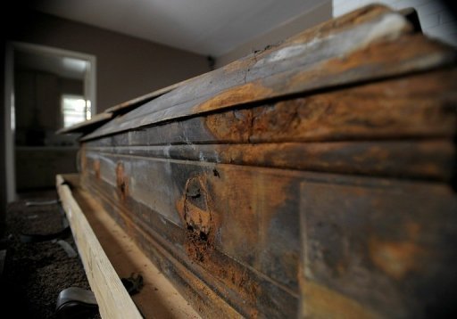 Selon la description du cercueil faite par la maison de vente, le couvercle a cede par endroits sous l'effet de l'humidite.