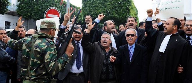 Des manifestants demandent la demission des ministres proches de Ben Ali qui figurent dans le nouveau gouvernement tunisien forme lundi 