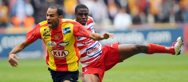L'attaquant de l'Esperance de Tunis, Saber Khlifa (en jaune et rouge), tacle par le defenseur du Club africain Khaled Souissi, lors du derby de Tunis le 21 novembre 2010.