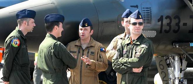 A Solenzara, le 11 avril 2011. On distingue sur le fuselage du Mirage 2000-D (juste a droite de la tete du pilote de droite) les silhouettes de 8 bombes guidees GBU et d'un missile SCALP-EG tires par ce seul avion depuis le debut des frappes, le 19 mars.