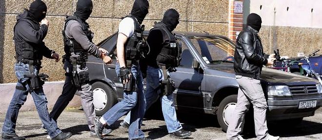 Des policiers sortent de l'appartement de Mohamed Merah a Toulouse, le 23 mars 2012.