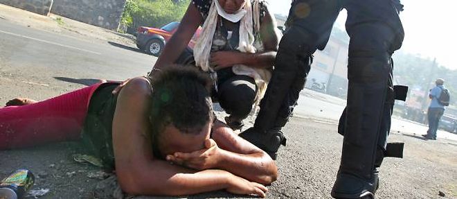 Un gendarme surplombe une manifestante lors des emeutes survenues en octobre 2011 a Mamoudzou a Mayotte.