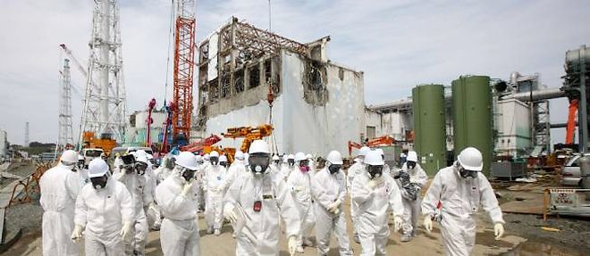 Des professionnels du nucleaire et des journalistes visitent le site de la centrale accidentee de Fukushima le 26 mai 2012. En arriere-plan, le reacteur n? 4. 