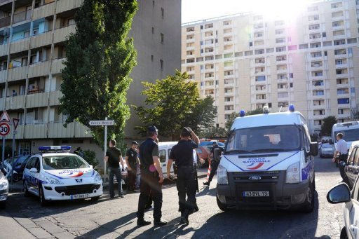 Policemen stand guard at the Lauriers residence where a 25 year old man was killed by a burst of Kalashnikov rifle fire, in the 13th arrondissement of Marseille, on July 29, 2012, according to sources close to the investigation. The source said the man was chased by a pickup truck before being shot at and the police are investigating. AFP PHOTO / ANNE-CHRISTINE POUJOULAT
