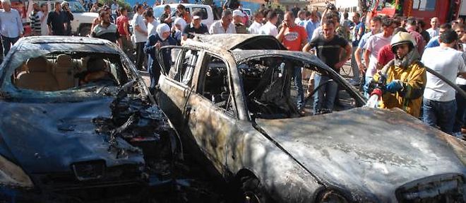 Des voitures calcinees dans un attentat a Damas, vendredi.