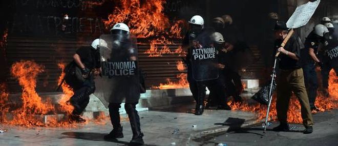 Des policiers cernes par les flammes, mercredi a Athenes.