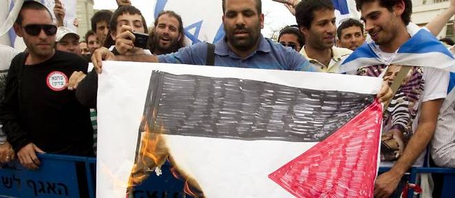 Des manifestants israeliens de droite mettent le feu a un drapeau palestinien, en face de l'universite de Tel-Aviv, le 14 mai dernier.