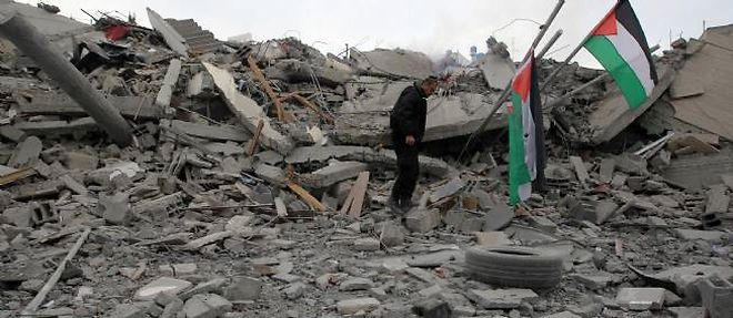 Un membre de la securite du Hamas inspecte les decombres du bureau du Premier ministre du Hamas a Gaza City, Ismail Haniyeh, detruit par des raids israeliens.