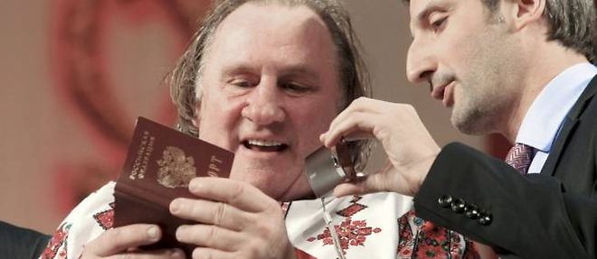 Revetu de l'habit traditionnel mordve, Gerard Depardieu admire son passeport tout neuf lors de son deplacement en Mordovie dimanche.