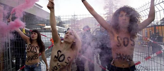 Trois militantes de Femen defilent seins nus devant le Forum economique de Davos en Suisse.
