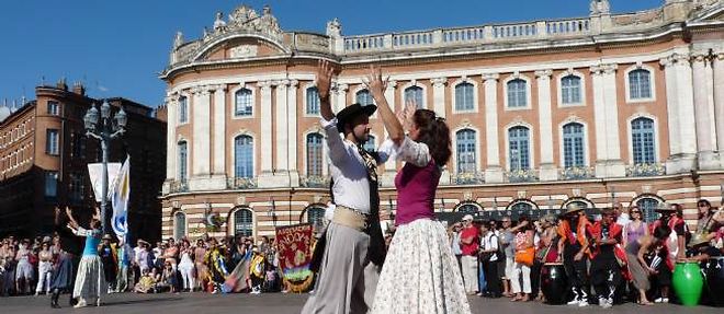 Un couple danse a Toulouse sur la place du Capitole.