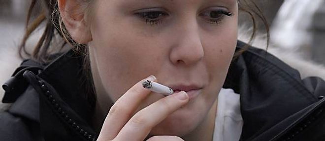 Une jeune femme fume une cigarette, a Copenhague, en 2012.