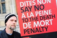 Curtis McCarty, ancien condamne a mort aux Etats Unis, innocente apres 19 ans pose a cote d'une pancarte contre la peine de mort a Paris. (C)Julien Muguet