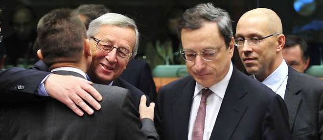 Le Premier ministre luxembourgeois Jean-Claude Juncker donne l'accolade au ministre grec des Finances Yannis Stournaras. A droite, Mario Draghi, president de la BCE. Bruxelles, novembre 2012.