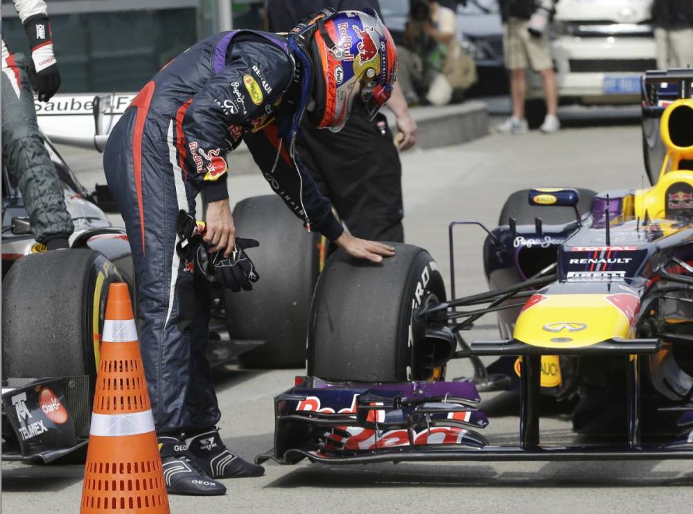 Sebastian Vettel examinant ses pneus qu'il a ménagé car il compte prendre l'ascendant au départ du Grand Prix, c'est le cup de poker tenté par le pilote allemand.