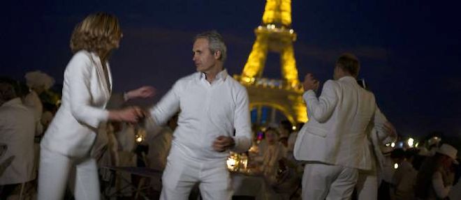 Des participants au 25e Diner en blanc devant la tour Eiffel jeudi soir.