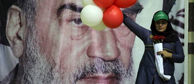 Une supportrice du candidat conservateur Ali Akbar Velayati porte des ballons devant le portrait de l'ayatollah Khomeiny, a Teheran, le 12 juin.