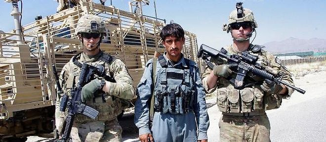 Le 5 juin 2013, un policier afghan pose avec des soldats de l'Otan.