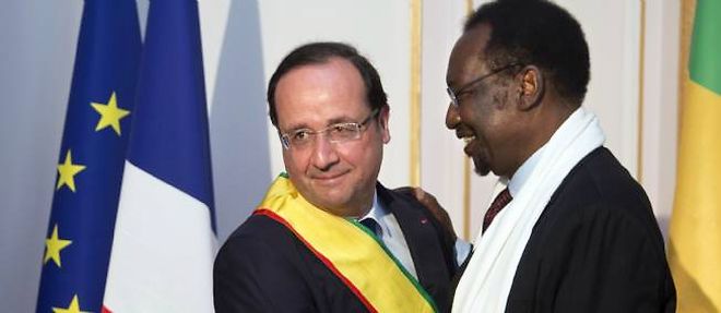 Francois Hollande, vetu de l'echarpe du Mali, enlace le president malien de transition Dioncounda Traore, a l'ambassade du Mali a Paris.