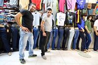 Deux jeunes Iraniens posent dans un magasin de jeans, au bazar de Tajrish, à Téhéran, le 7 octobre 2013. ©ATTA KENARE