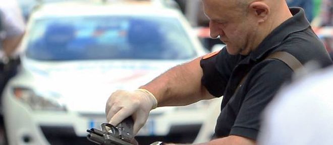 Un policier ramasse une arme devant la bijouterie La Turquoise, le 11 septembre 2013, a Nice.