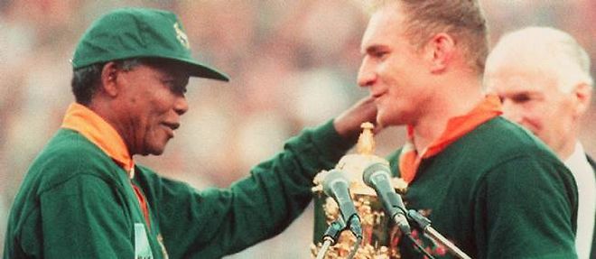 Nelson Mandela felicite le capitaine de l'equipe de rugby d'Afrique du Sud, Francois Pienaar, le 24 juin 1995, a Johannesburg.