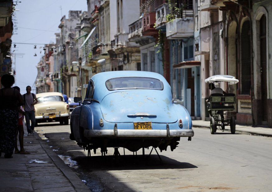 Scène de a vie courante à Cuba avec ce garage de rue et une voiture en attente de l'hypothétique pièce manquante.