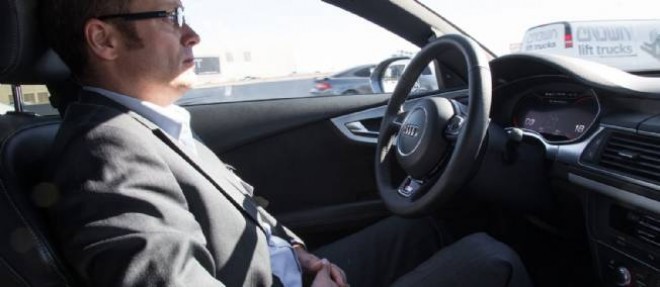 Plutot que se tourner les pouces, le conducteur d'une Audi equipee du "Piloted Driving peut occuper son temps en lisant ou en communiquant par visioconference.