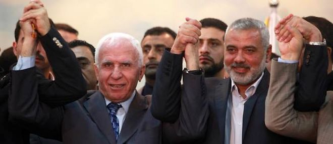 Le Premier ministre du Hamas, Ismail Haniyeh (a droite), main dans la main avec Azzam al-Ahmad (a sa gauche), chef de la delegation de l'OLP, venu signer la reconciliation avec le mouvement islamiste a Gaza.