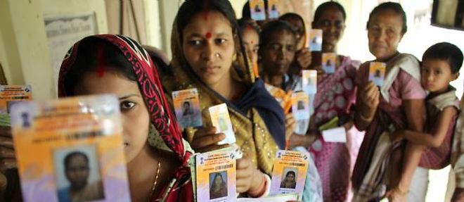Dans l'Etat d'Assam, des femmes montrent leur carte d'electeur.