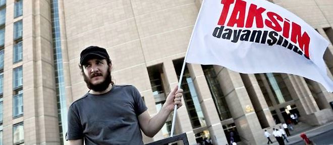Un militant porte un drapeau "Taksim Solidarite" devant le palais de justice ou doivent etre juges une douzaine de manifestants.