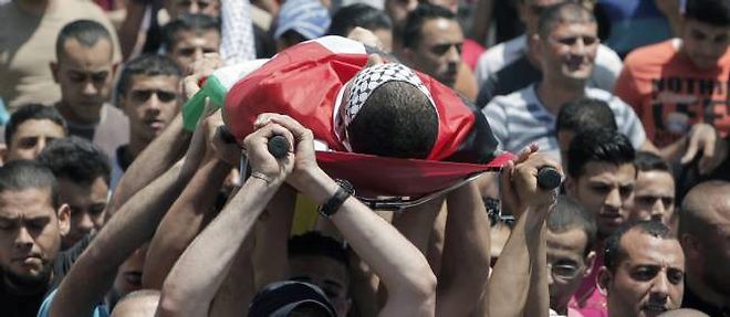 Des Palestiniens portant le corps d'Ahmed Fahnawi, 27 ans, tue le 22 juin par l'armee israelienne parce qu'il s'etait approche, selon Tsahal, "de maniere menacante" de ses soldats.