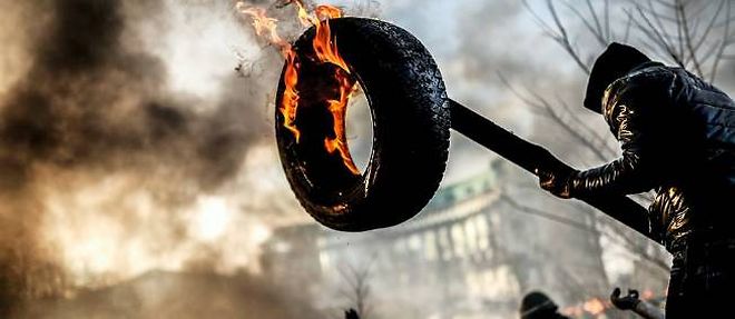 Des manifestants anti-gouvernement brulent une barricade pendant la crise ukrainienne.