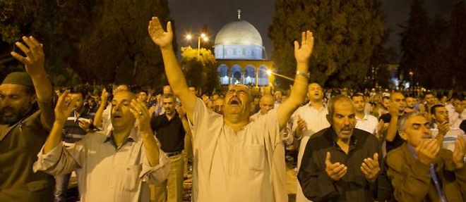Des Palestiniens prient devant le dome du rocher, a Jerusalem, dimanche soir.
