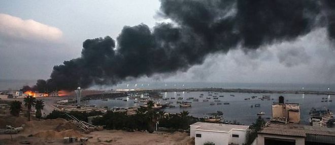 Un building du port de Gaza en feu, mardi matin.