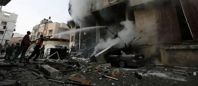 Des pompiers tentent d'eteindre un incendie consecutif a un bombardement israelien, mardi matin a Gaza City.