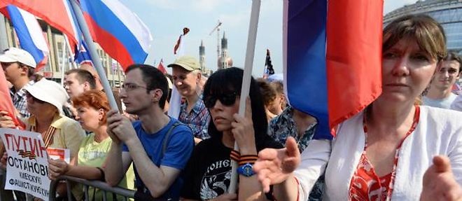 Des manifestants agitent le drapeau russe et celui de la region du Donbass a Moscou samedi 2 aout 2014.