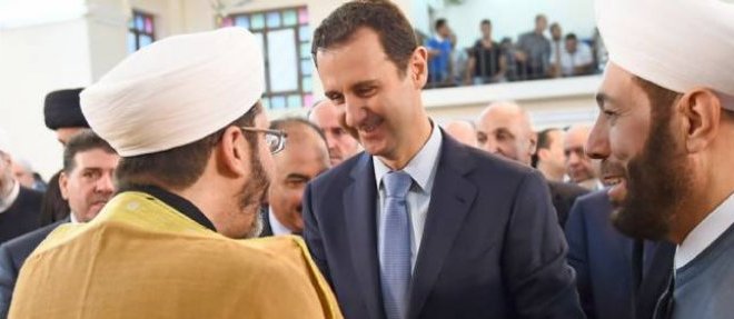 Le president syrien Bachar el-Assad discourant avec le grand mufti syrien Ahmed Hassun (a droite) avant la priere de l'Aid-el-Fitr, le 28 juillet 2014. Photo d'illustration.