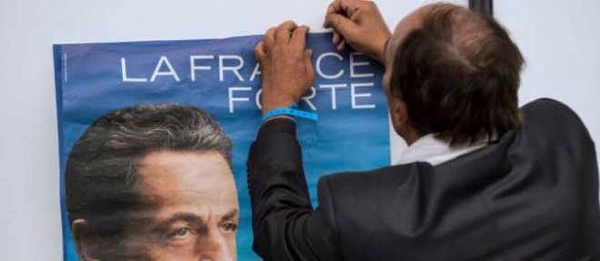 Un sympathisant UMP epingle une affiche representant Nicolas Sarkozy, le 30 aout 2014 au Touquet.