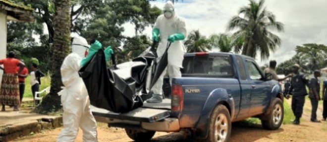 Des ramasseurs emportent le corps de Dewell Doe, un petit garcon de 12 ans, victime d'ebola a Virginia, un bidonville de Monrovia, la capitale du Liberia.
