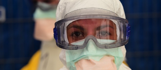 Une volontaire de Medecins sans frontieres arbore des protections sur les yeux et la bouche, ainsi qu'une combinaison complete et des gants, pour se proteger du virus.
