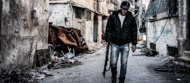 Un combattant rebelle marche seul dans une rue d'Alep devastee, le 25 octobre 2014 (photo d'illustration).