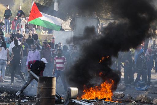 Des Arabes israeliens, certains arborant le drapeau palestinien, affrontent les forces de l'ordres a Kafr Kanna, en Israel, le 9 novembre 2014