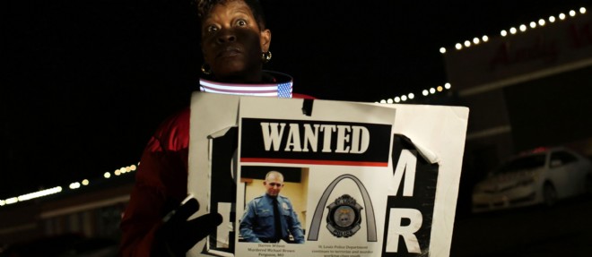 Une femme tient une pancarte representant Darren Wilson, le policier qui a tue debut aout le jeune Michael Brown.