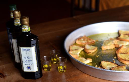 Des bouteilles d'huile d'olive et des morceaux de pain grilles en degustation au pressoir de Cesare Buonamici, le 2 decembre 2014 a Fiesole, pres de Florence, en Toscane