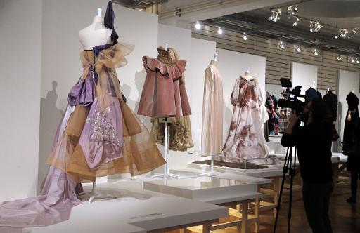 Une personne filme des robes dessinées par John Galliano et présentées dans le cadre de l'exposition "Fashion Mix" à Paris, le 8 décembre 2014 © François Guillot AFP