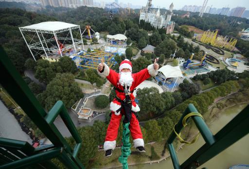 Un homme deguise en pere Noel saute a l'elastique le 18 decembre 2014 a Changsha, dans la province du Hunan dans le centre de la Chine