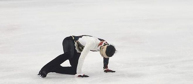 Le patineur vedette japonais Yuzuru Hanyu tente de se relever d'une chute dans l'epreuve libre lors du Grand Prix de Chine, le 8 novembre 2014 a Shanghai
