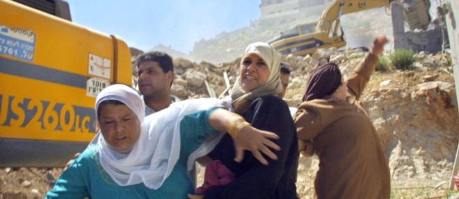 Un bulldozer israelien detruit des maisons de Palestiniens.